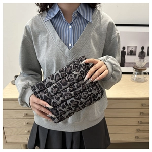 Detail of grey leopard print quilted clutch bag showing the soft padded nylon fabric texture