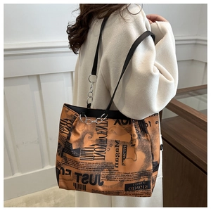 Dettaglio della borsa tote alla moda con stampa giornale vintage e manici in pelle