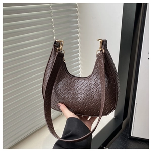 Detailed view of dark brown crescent bag featuring intricate woven texture and gold hooks