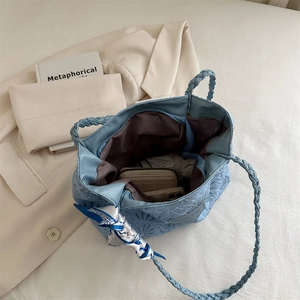 Light blue quilted tote bag with woven handles and silk scarf detail for work