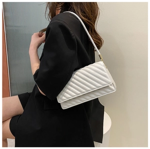 Détail du sac à bandoulière matelassé blanc avec coutures diagonales sur le mannequin