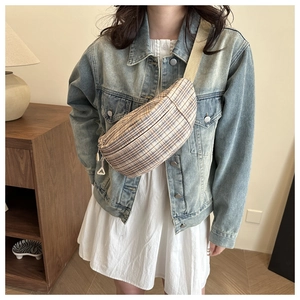 Close-up of a plaid crossbody chest bag with double zippers and adjustable wide strap