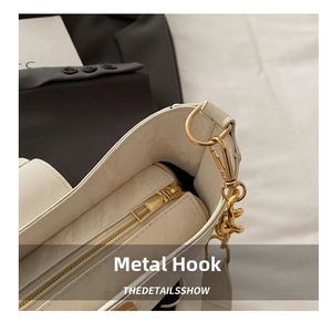 Detail of white textured shoulder bag featuring premium gold metal hook and chain link