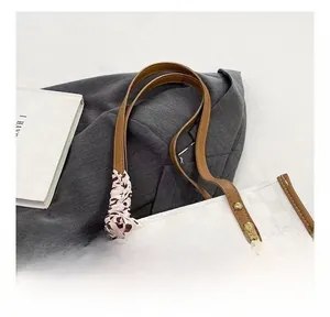 Detail of white checkered tote bag with brown leather straps and leopard print silk scarf