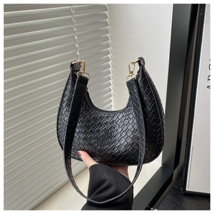 Close-up of woven texture on black crescent hobo bag with gold hardware detail