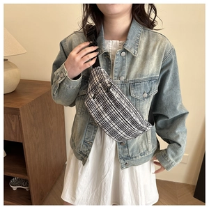 Close-up of black and white checkered crossbody waist bag with adjustable nylon strap