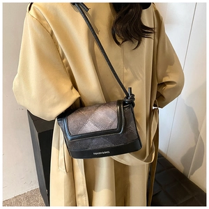 Detail of plaid crossbody bag with 'FASHION & BAGS' text on a stylish trench coat
