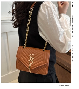 Détail du sac en cuir matelassé marron avec boucle en S dorée, franges et bandoulière