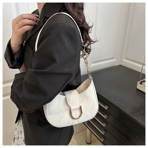 Detailed view of white marble texture underarm bag with gold horseshoe buckle and chain