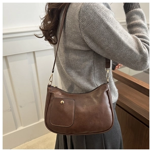 Vue détaillée latérale d'un sac hobo vintage marron avec boucle dorée sur un mannequin