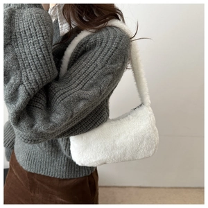 Close-up of fluffy white plush underarm bag showing soft texture and shoulder carry style