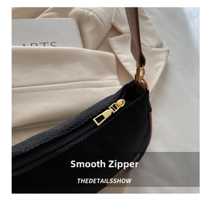 Macro detail of high-quality smooth metal zipper and black woven texture of the shoulder bag