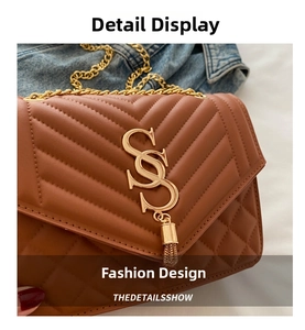 Close-up of brown quilted leather texture with gold chain strap and tassel detail
