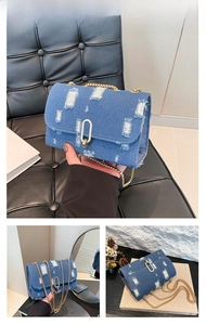 Close-up of dark blue denim bag with distressed details and gold chain strap