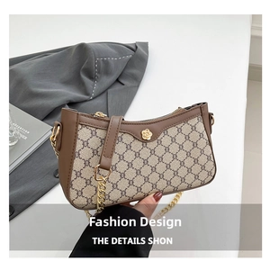Detail of vintage canvas baguette bag with golden floral hardware and brown leather trim