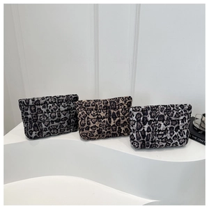 Detailed view of three quilted leopard print clutches in grey, tan, and dark brown tones