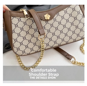 Detail of the chain shoulder strap and golden metal hardware on a brown leather handbag