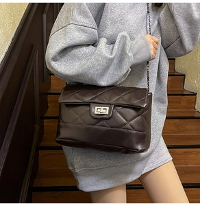 Close-up of quilted coffee brown shoulder bag with metal turn-lock and chain strap