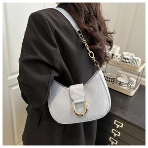 Close-up of light blue pleated hobo bag with gold horseshoe buckle and chain strap