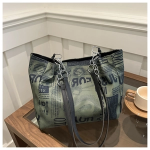 Dettaglio borsa shopper in tela con stampa vintage e spalline in pelle e metallo