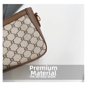 Close-up of vintage monogram fabric and brown leather trim with gold metal hardware