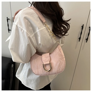 Detail of light pink crescent shoulder bag with pleated texture and gold chain strap