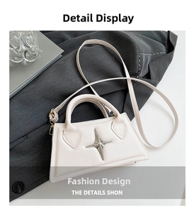Détail du sac trapèze blanc cassé avec boucle en forme d'étoile et doubles poignées