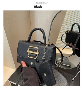Detail of black litchi pattern leather handbag with gold buckle and matching coin purse
