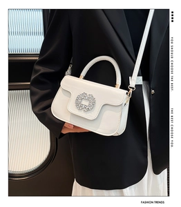 Détail du sac bandoulière en cuir blanc avec serrure en strass et bandoulière assortie