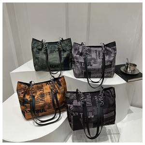 Detail of trendy tote bags with newspaper print in four colors and chain straps