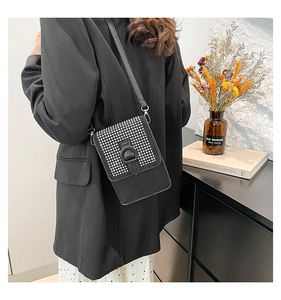 Vue détaillée d'un sac bandoulière noir élégant en cuir avec façade en strass brillants
