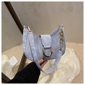 Macro detail of light blue textured hobo bag with a prominent gold D-ring buckle hardware