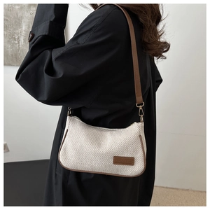Detail of woven cream tweed shoulder bag with brown leather trim and shoulder strap