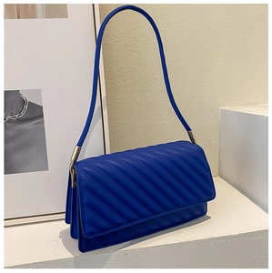 Détail du sac à bandoulière matelassé bleu roi avec coutures diagonales et ferrures dorées