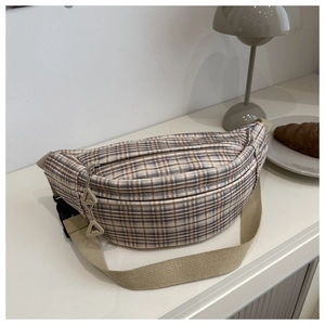 Detail of checkered corduroy chest bag with adjustable strap in a minimalist setting