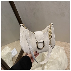 Detail showing marble texture shoulder bag with gold horseshoe buckle and chain decoration