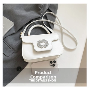 White leather handbag with diamond buckle shown next to a smartphone for size comparison