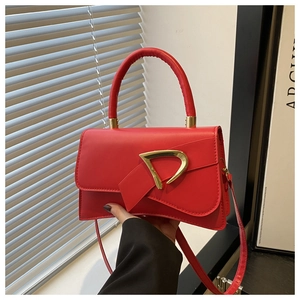 Dettaglio della borsa in pelle rossa con fibbia a D dorata e elegante manico superiore