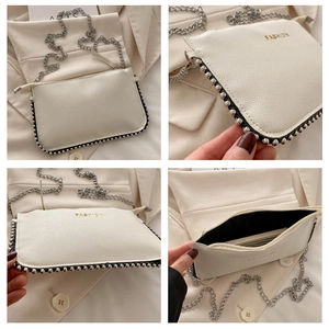 Detail view of white lychee leather crossbody bag with silver bead trim and metal chain