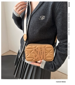 Detail of camel square crossbody camera bag with 3D SM letter and quilted pattern