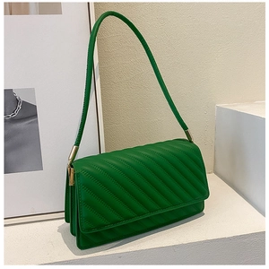 Détail du sac à bandoulière matelassé vert émeraude avec coutures et accents dorés