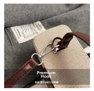 Detailed macro view of high-quality silver metal hook and leather strap on woven bag