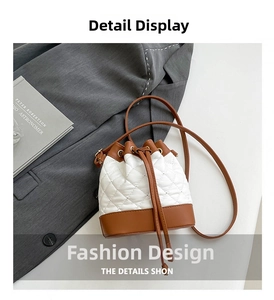 Close-up of quilted contrast bucket bag with drawstring closure on gray blazer