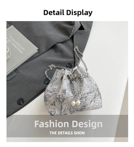 Détail du sac seau argenté avec broderie florale, chaîne et breloques en perles