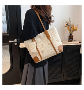 Detailed shot of canvas tote bag with brown leather trim and matching pouch