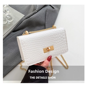 Détail du sac bandoulière blanc texture crocodile avec chaîne dorée et fermoir rotatif