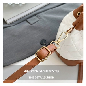 Close-up of adjustable brown leather shoulder strap with gold-tone hardware and quilted leather