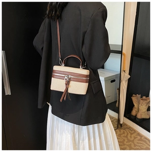 Detail view of retro color-block box bag worn by model showing its actual size and texture