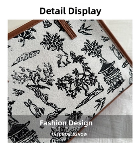 Macro detail of Chinese embroidery pattern on beige tote bag with premium leather trim