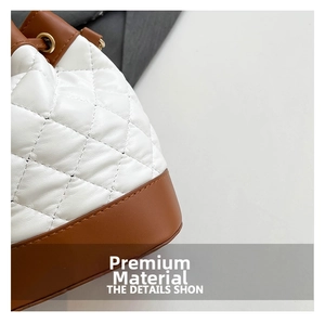 Detail of white quilted leather bucket bag with brown trim and gold eyelets